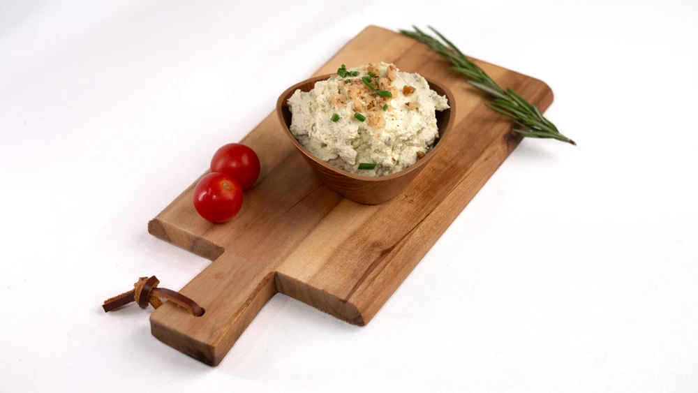 Frischkäse Rucola & Walnuss auf einem Holzbrett